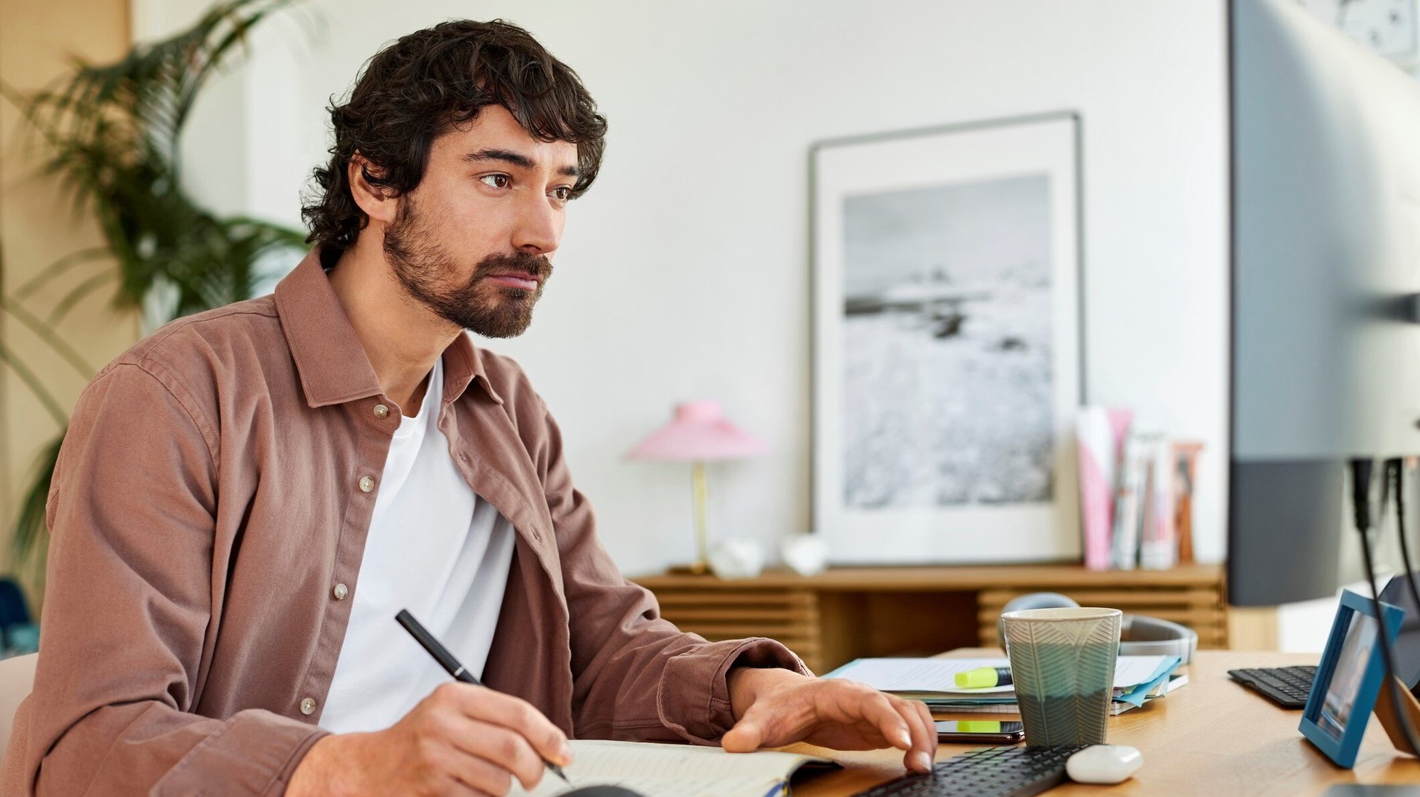 A man takes notes as he participates in a translated elearning course