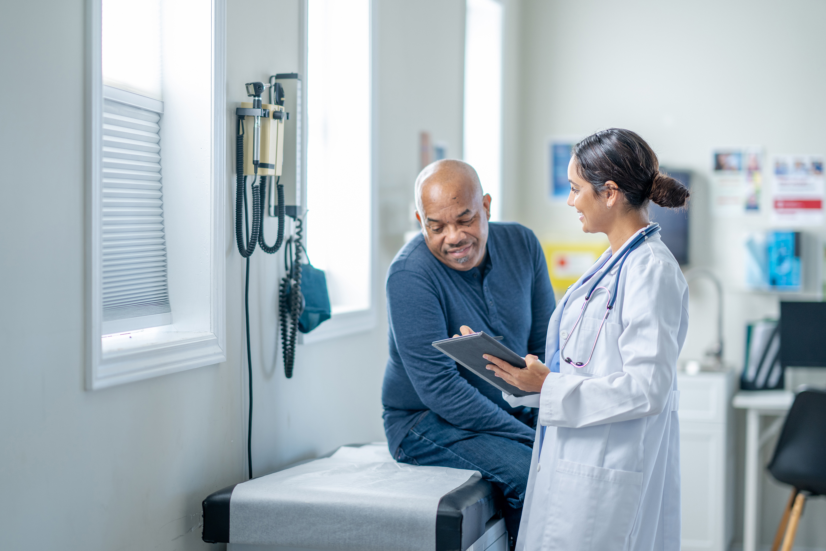 A doctor speaks to a patient with the help of an interpreter on an ipad.