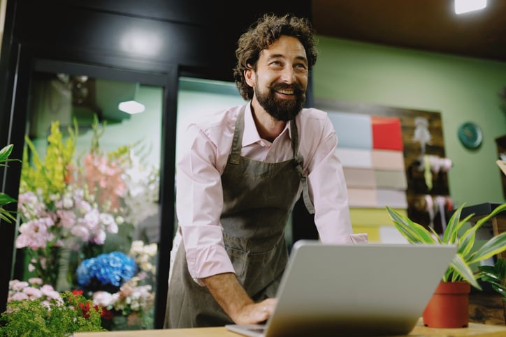 A flower shop owner talks to a customer with the help of an interpreter