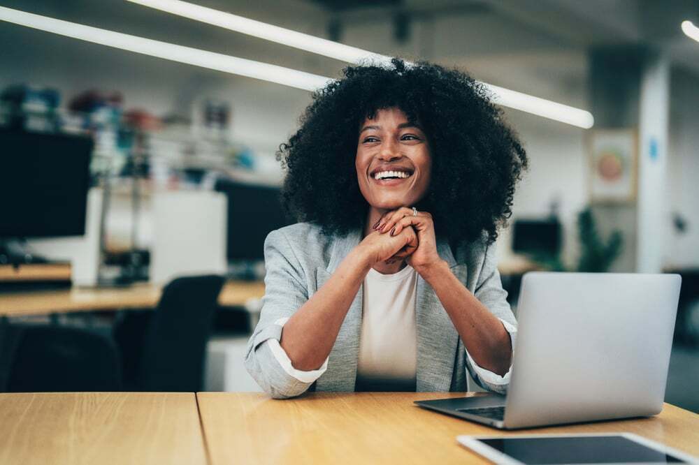 A woman smiles after reviewing a translated document online.