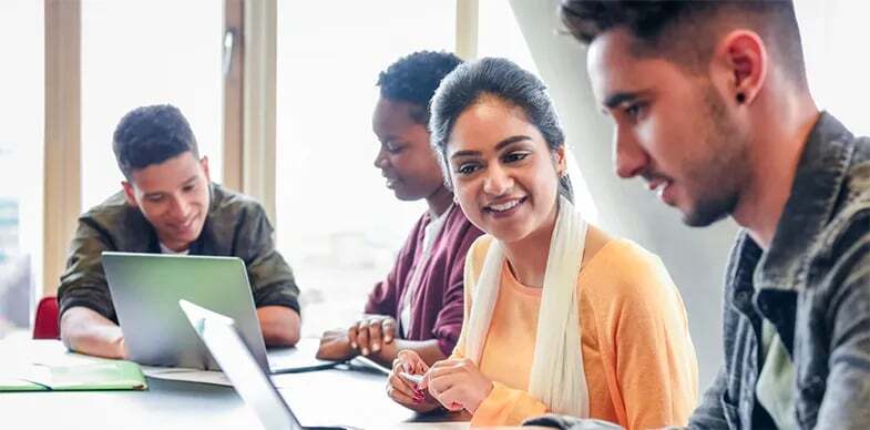 Two students look at translated course documents online.