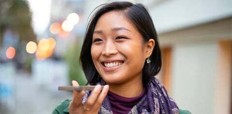 A customer smiles as she talks to a business with the help of an interpreter.