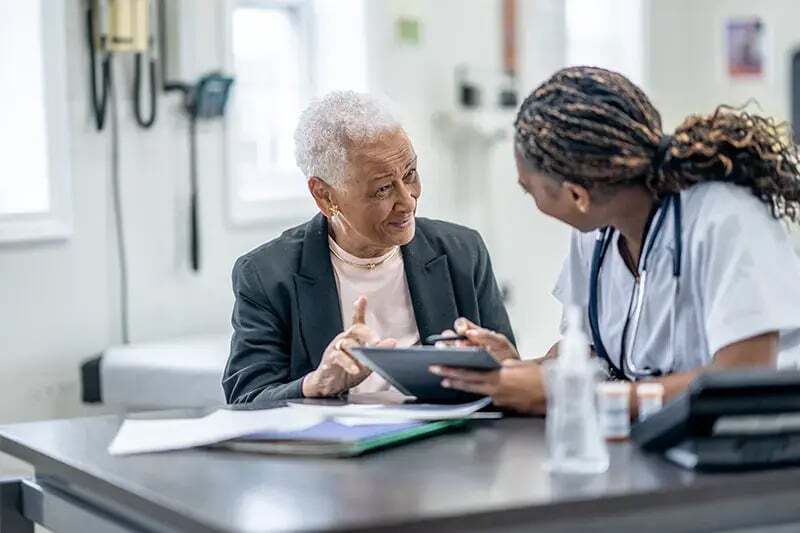 A medical worker speaks to a patient with the help of an interpreter