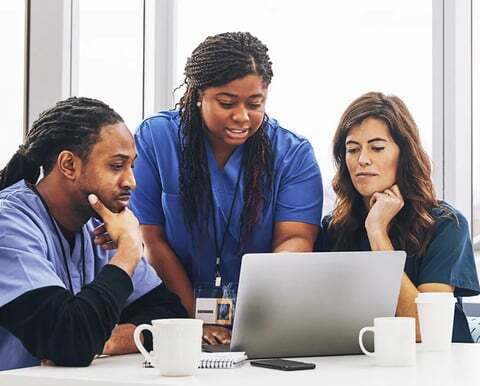 Three healthcare workers interact on a telehealth call with an interpreter