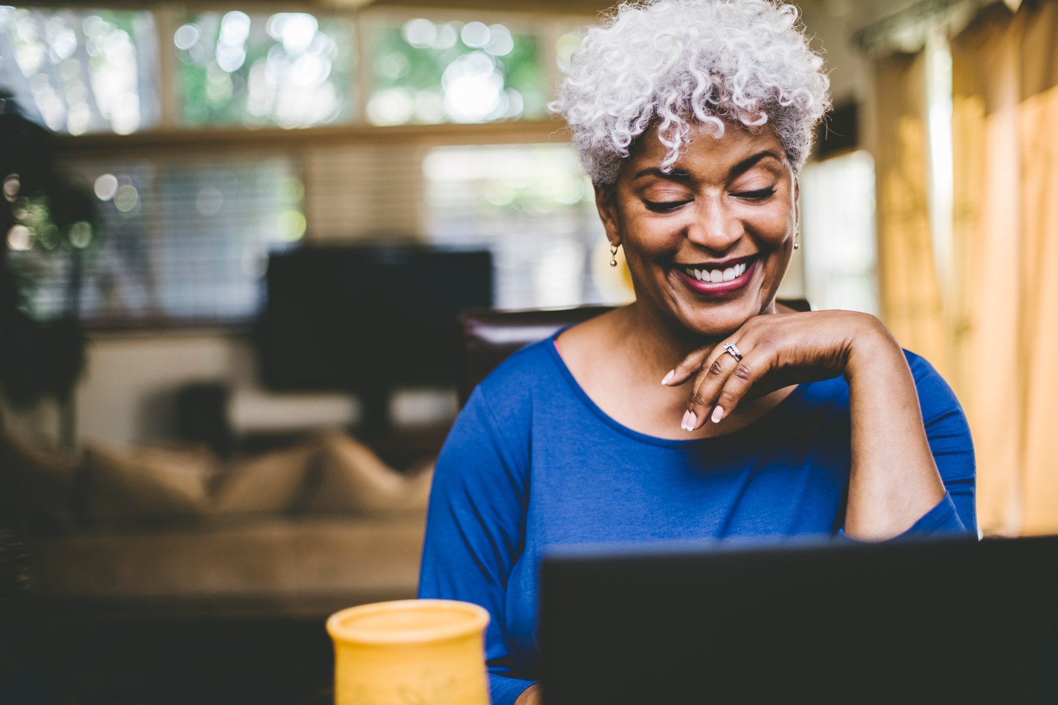 A client smiles as she turns in a TranslateExpress project on her computer.