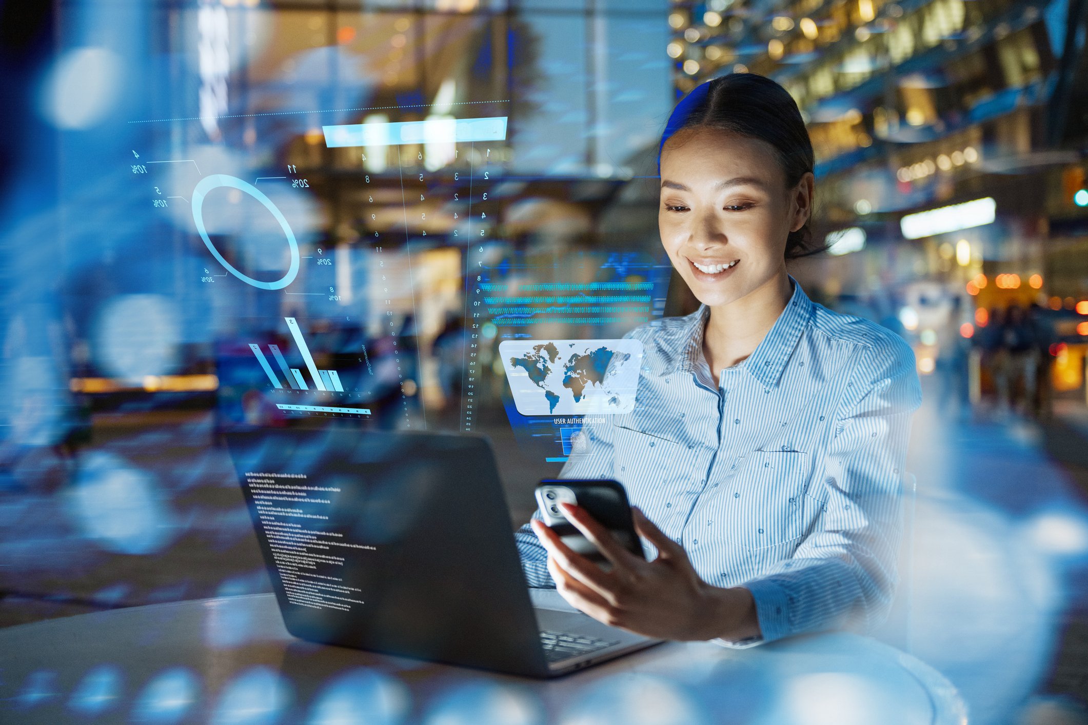 A woman works on different platforms with screens reflected back at her