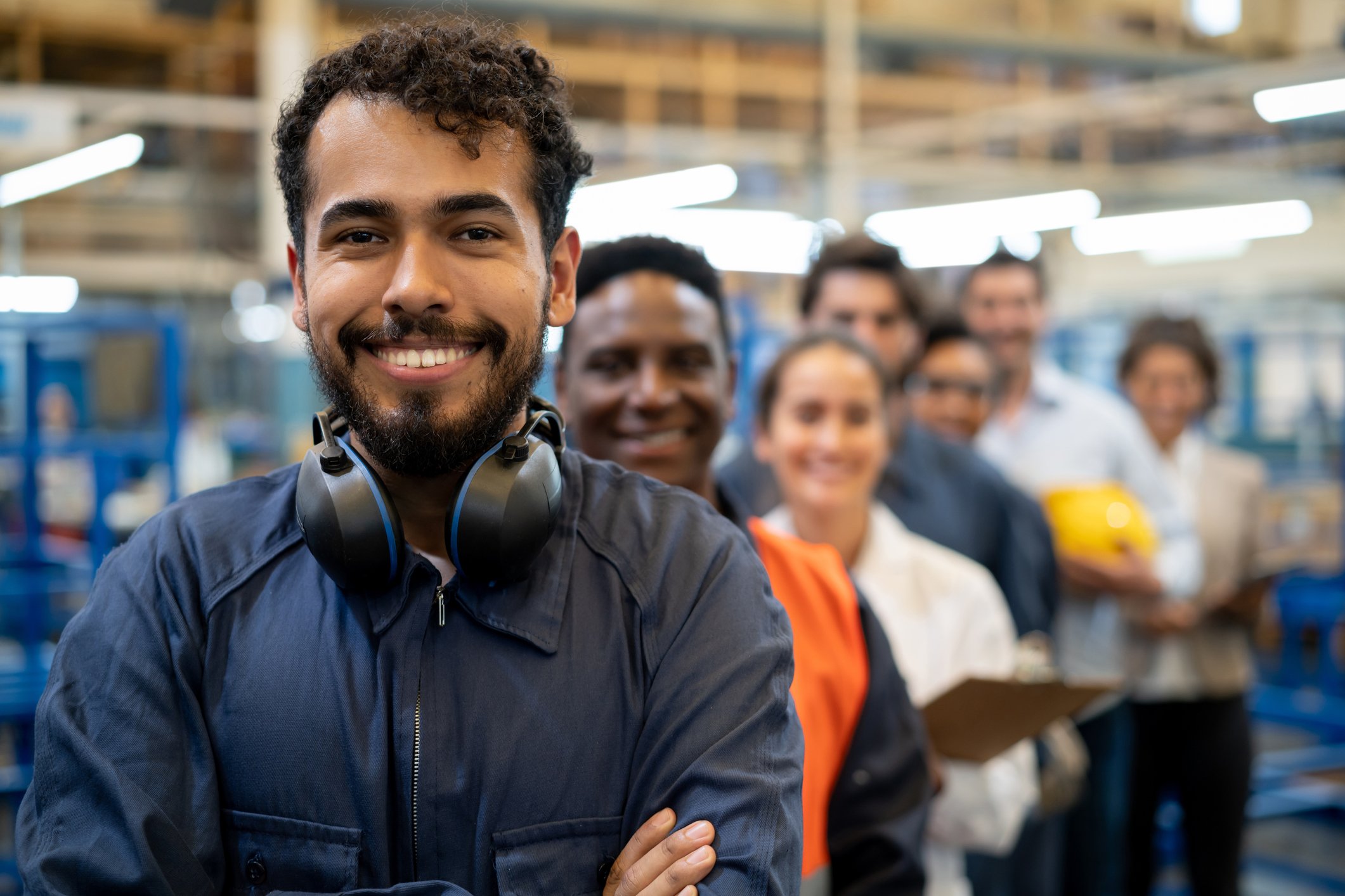 A group of manufacturing workers look pleased.