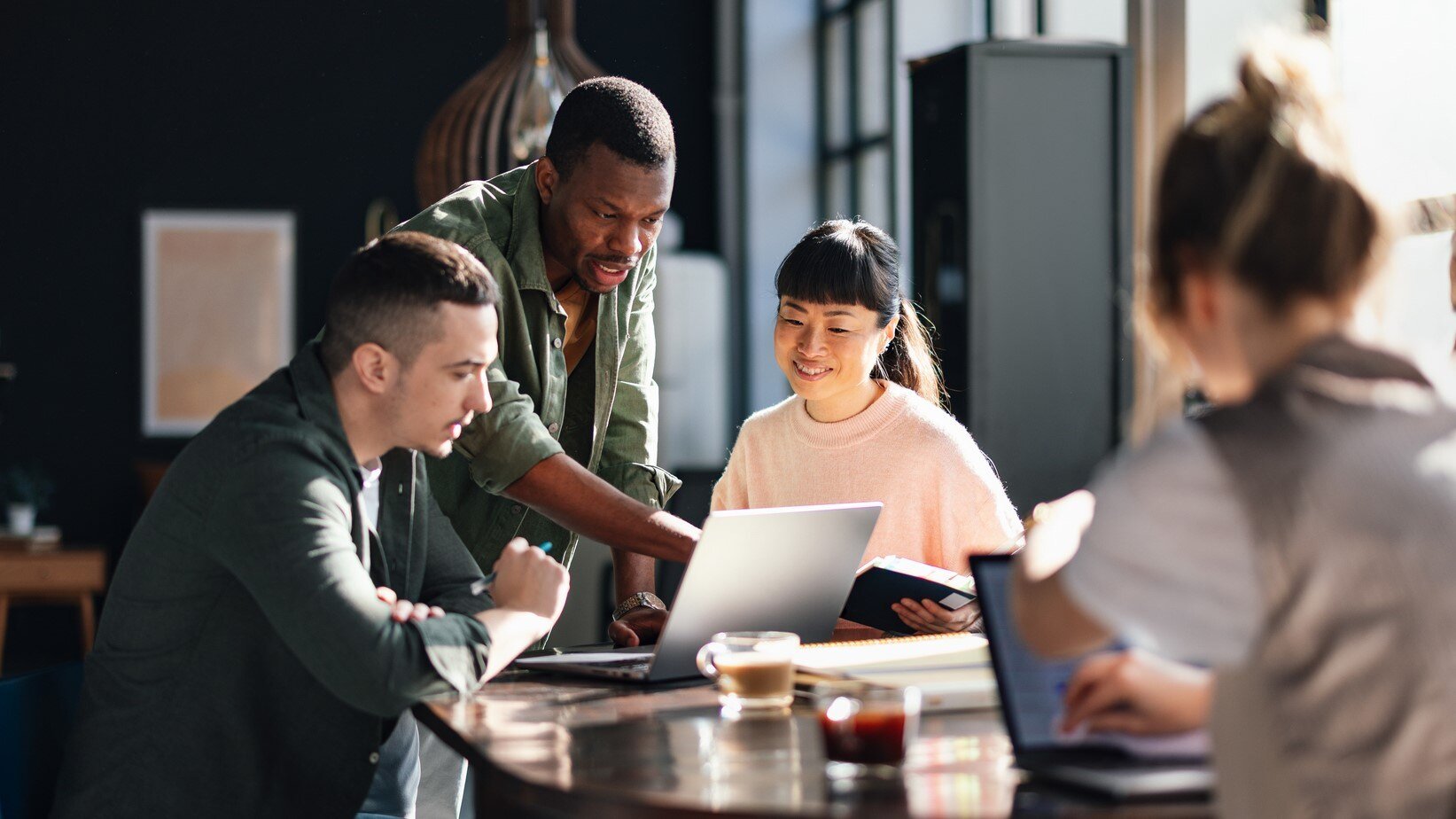 A group of coworkers looks at a translated document on a computer