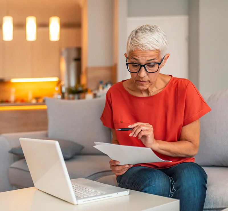 A woman examines a document, comparing it to an on-screen simplification of the contents.