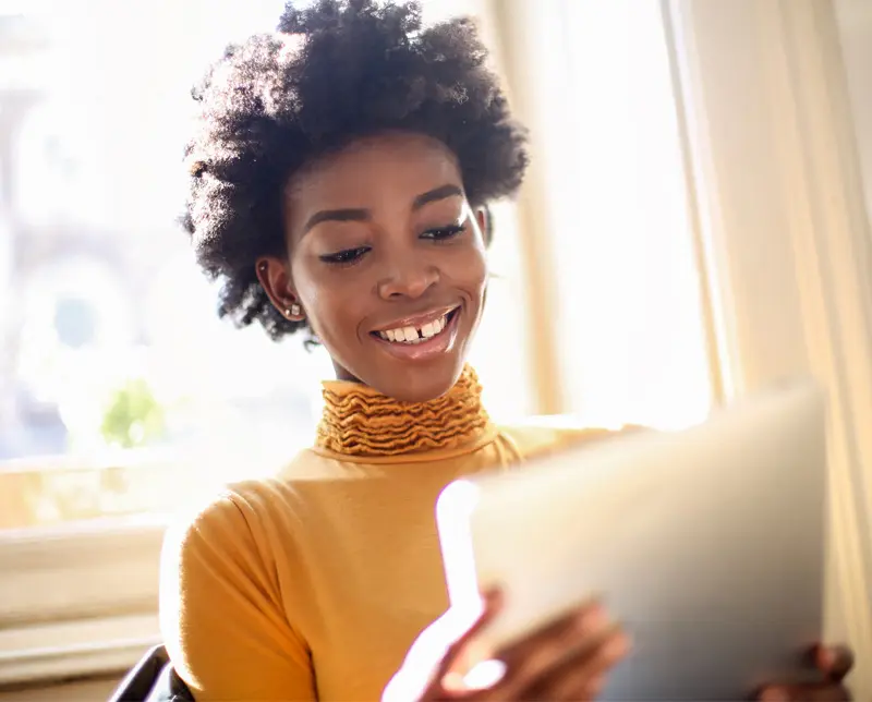 A smiling woman enjoys a localized website on her tablet